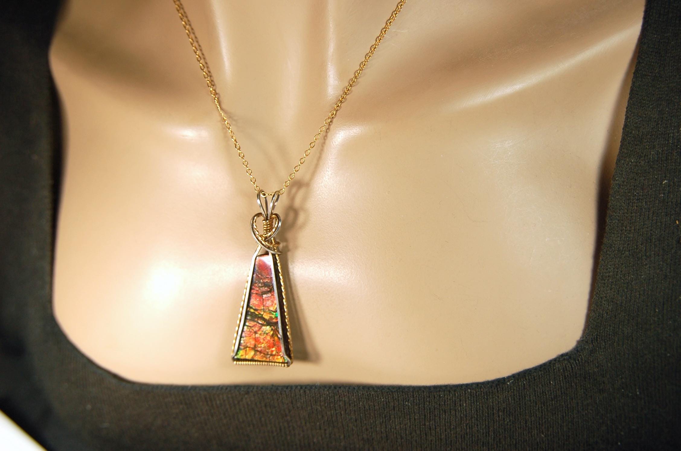 Unique Ammolite pendant set in Gold and sterling silver wire wrap.Natural cabochon in Canadian Maple fall colors.Must see video.082814