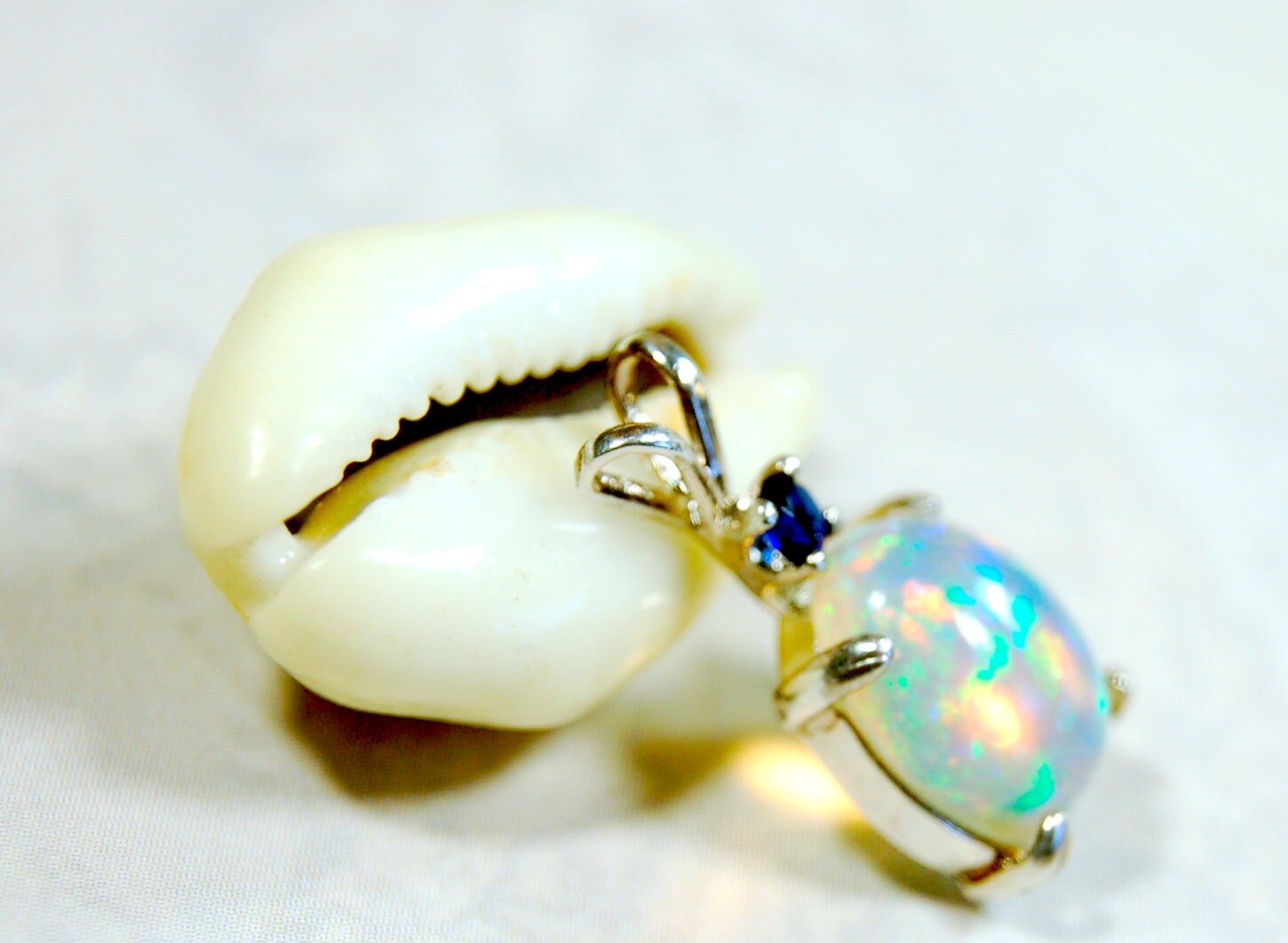 Natural opal pendant with blue sapphire.Good quality with many colors.The perfect gift.Must see video for true colors.042114