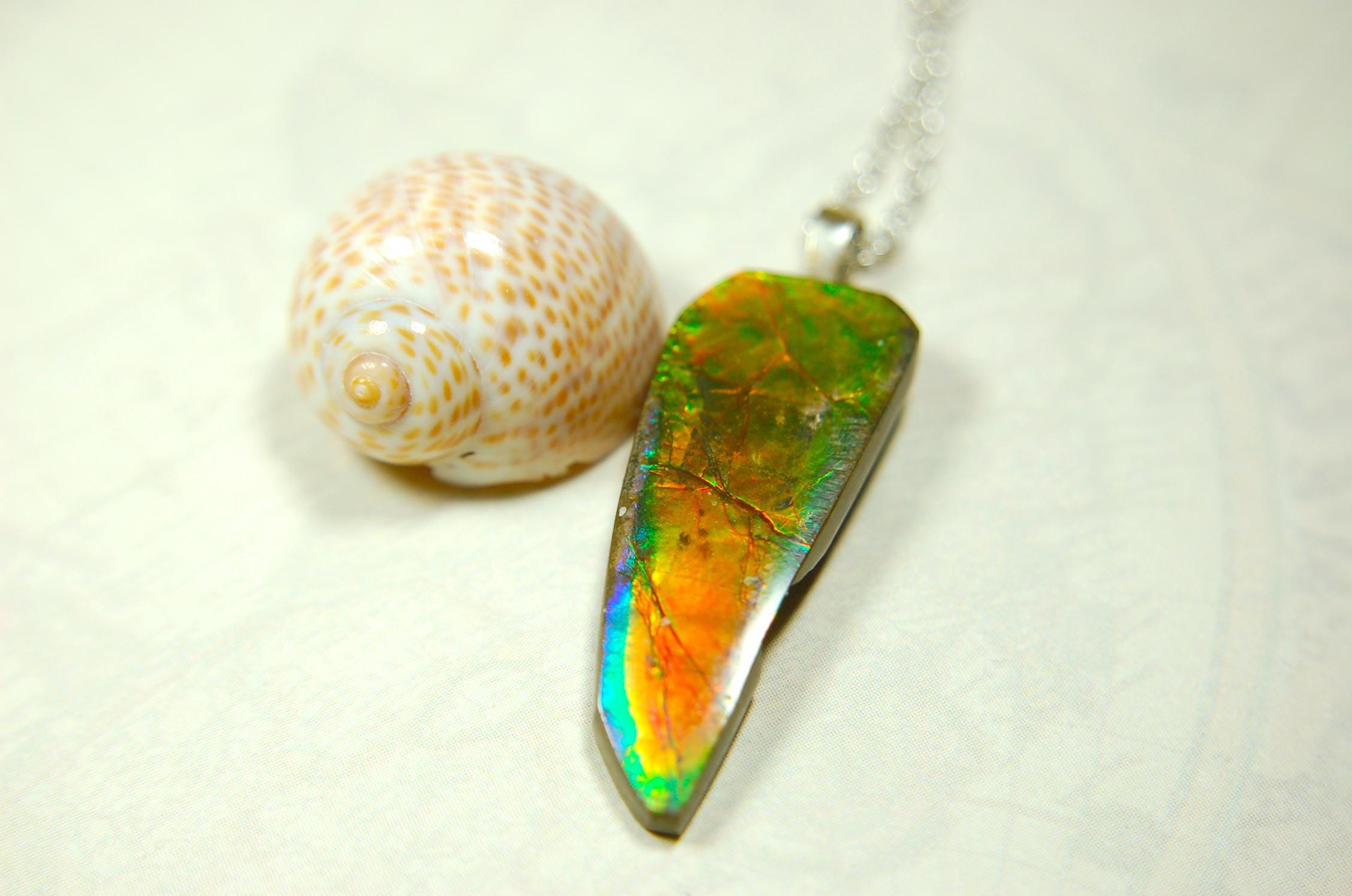 Ammolite necklace pendant.Natural rainbow cabochon of many bright colors.Strong color shifter.Video shows color best.030116