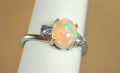 Opal ring.Solid African opal set in sterling silver with London Blue Topaz accent stones.Very feminine in size 6.