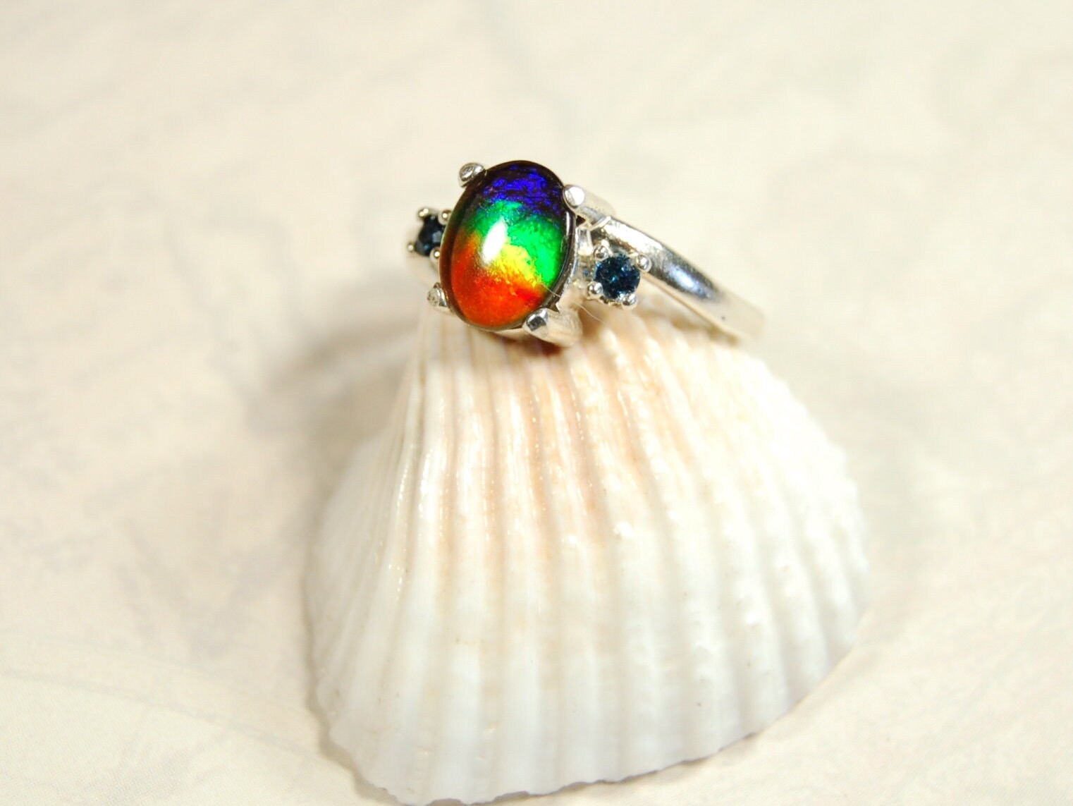Ammolite Ring with Sapphire side stones.Lovely four color gem.Size 7.-#040314