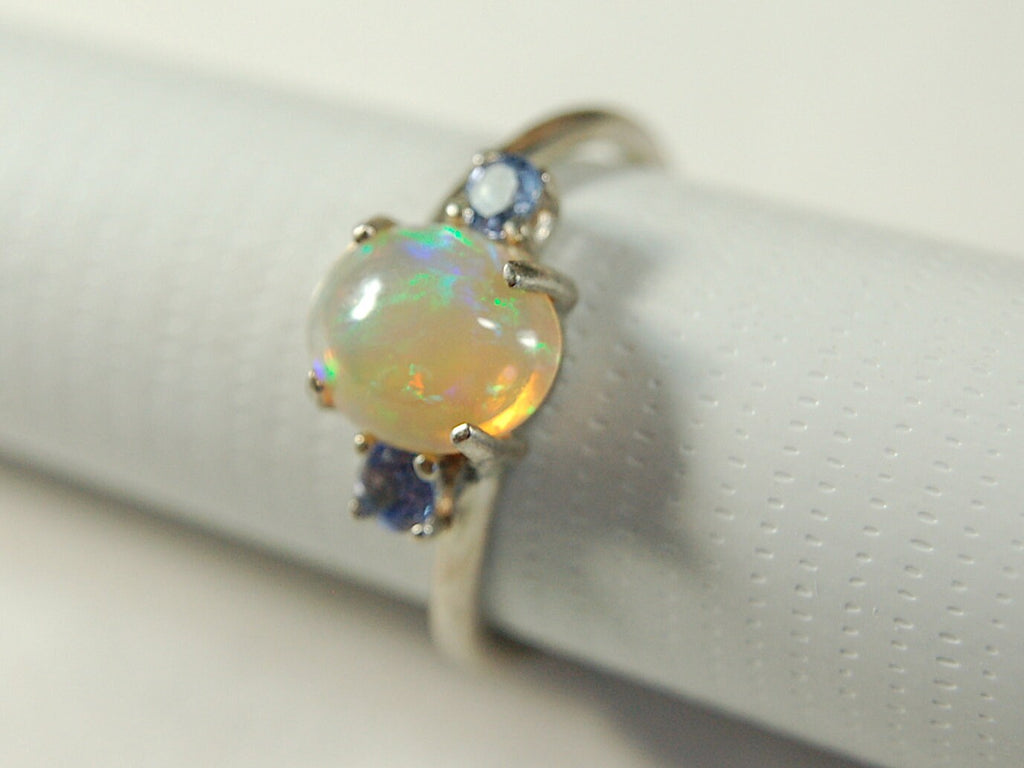 Opal ring.Solid African opal set in sterling silver with London Blue Topaz accent stones.Very feminine in size 6.