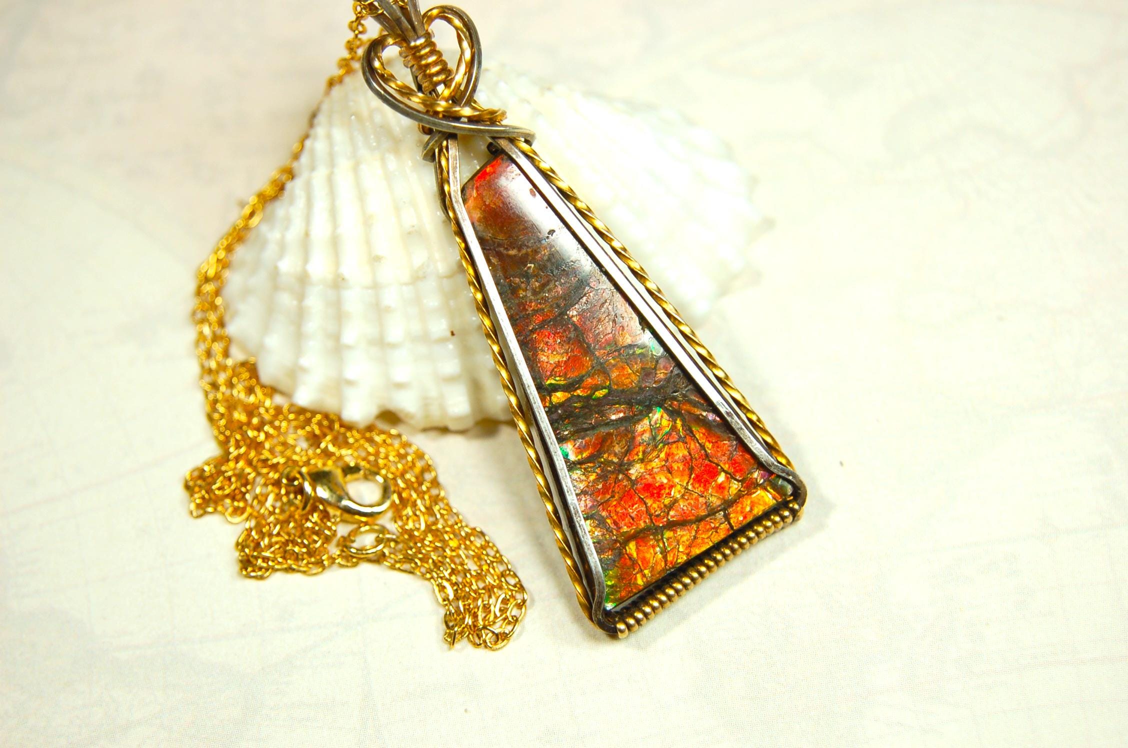 Unique Ammolite pendant set in Gold and sterling silver wire wrap.Natural cabochon in Canadian Maple fall colors.Must see video.082814