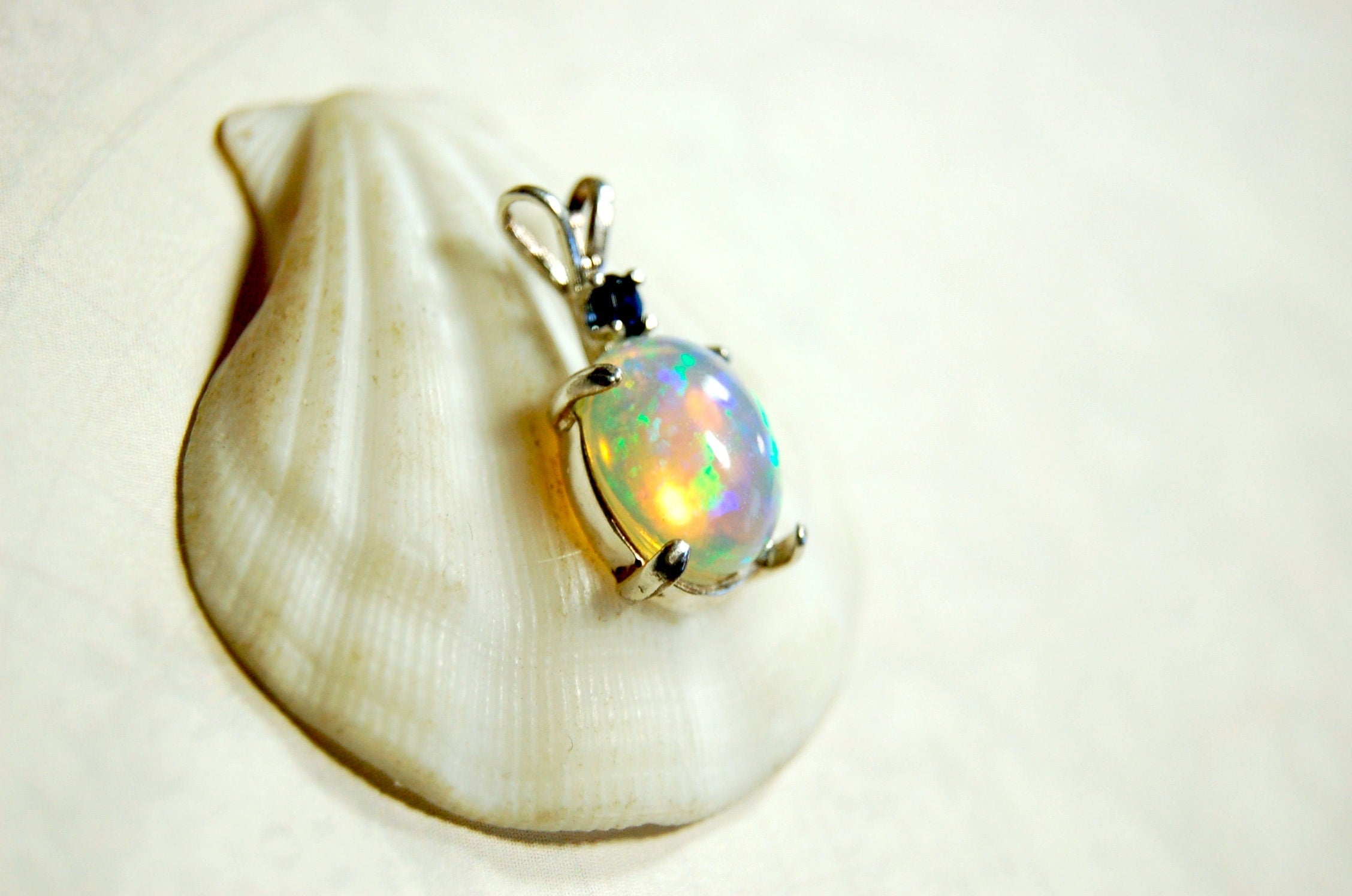 Natural opal pendant with blue sapphire.Good quality with many colors.The perfect gift.Must see video for true colors.042114