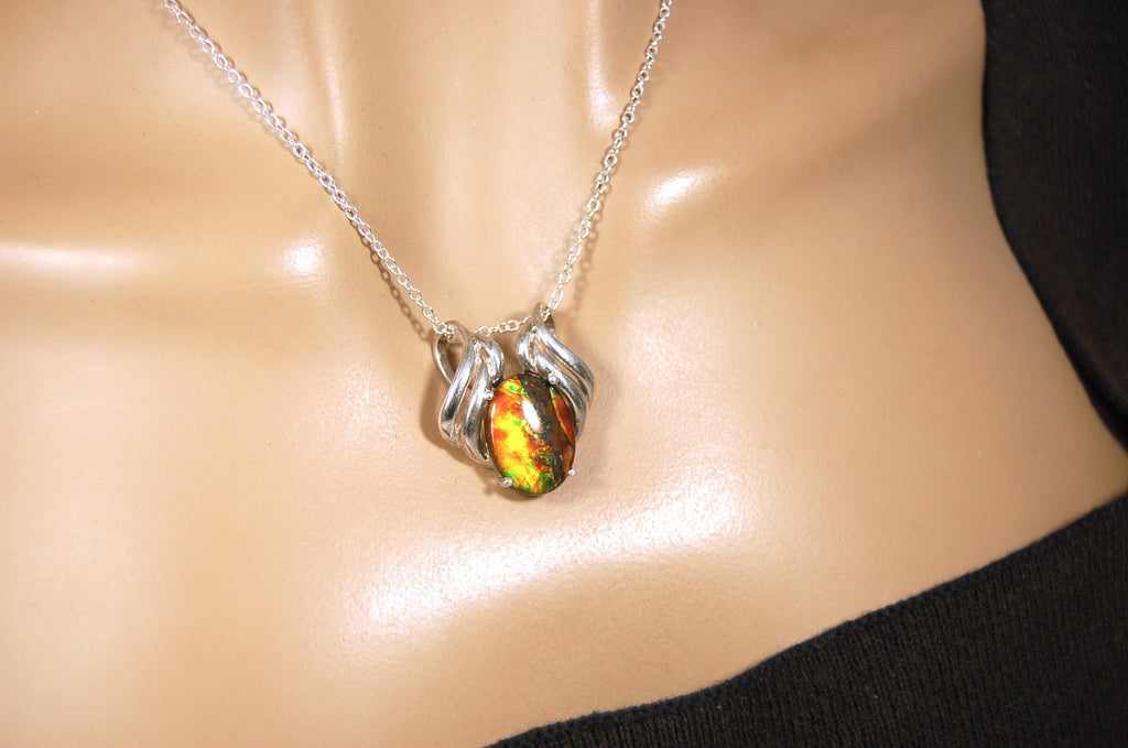 Ammolite pendant of unusual color pattern in a rare sterling silver setting.The green/copper colors are striking.022116