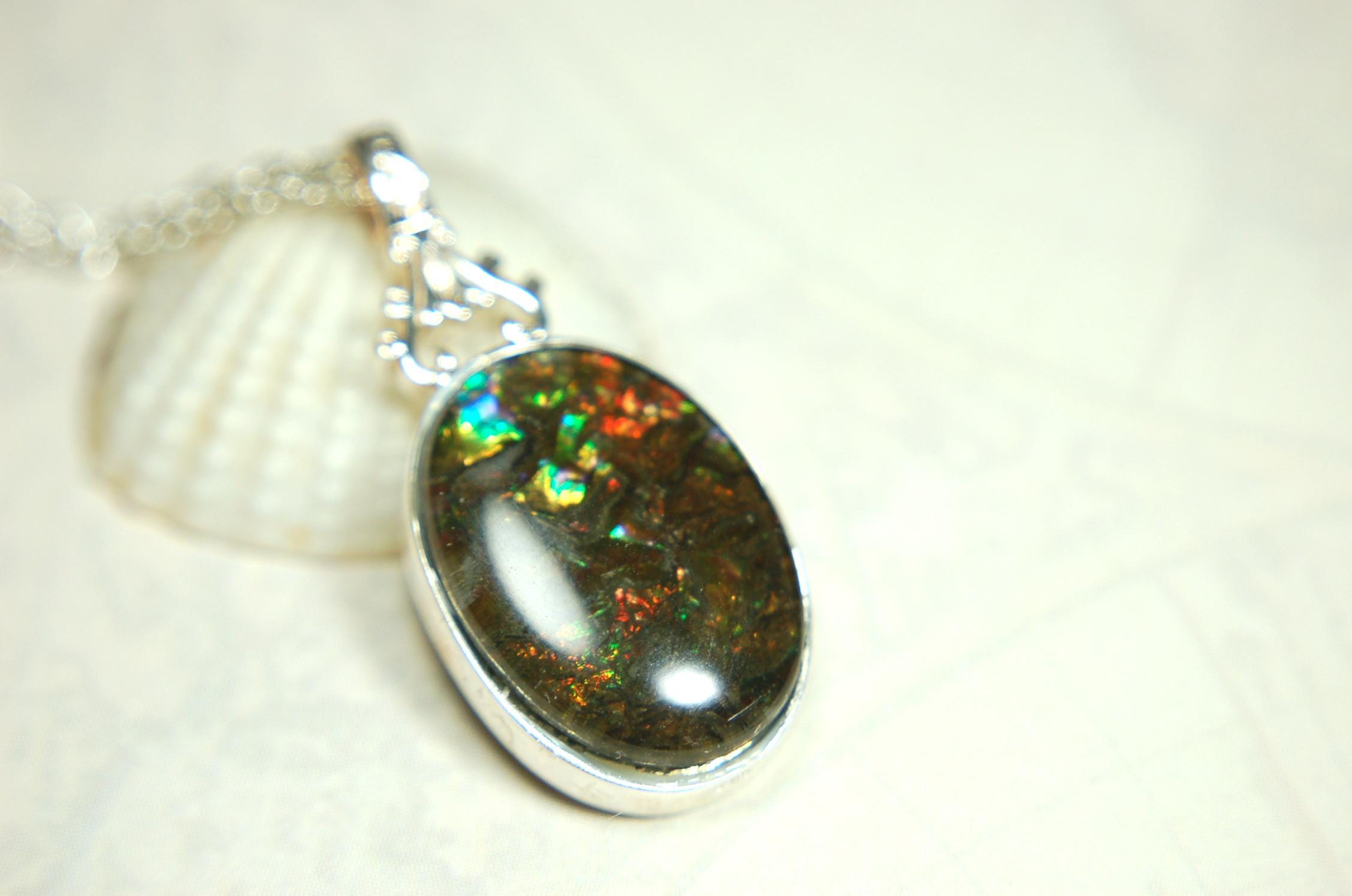 Ammolite Pendant.Rare sparks of color.Looks like a black Opal.One of a kind gem.Rare gift for her.Sterling Silver setting.022316