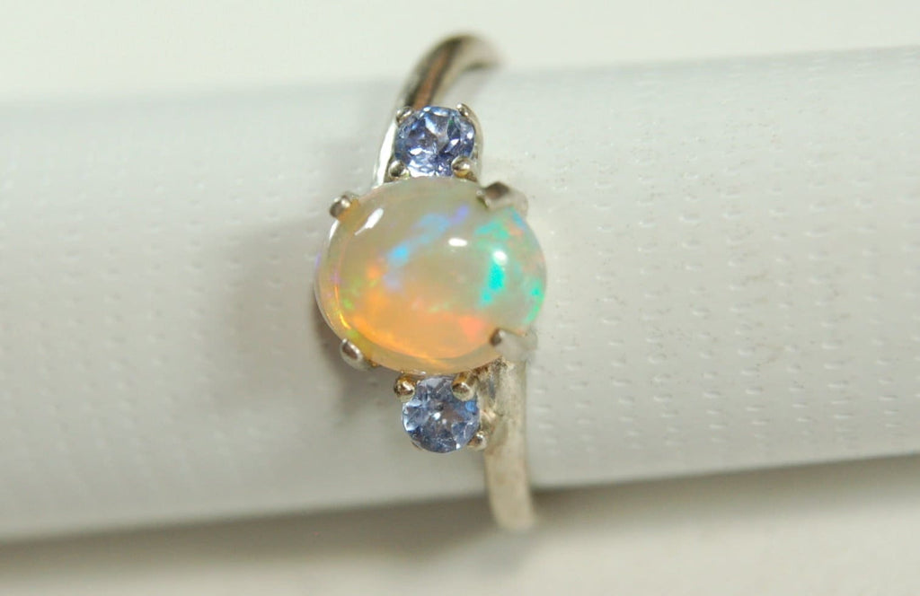 Opal ring.Solid African opal set in sterling silver with London Blue Topaz accent stones.Very feminine in size 6.
