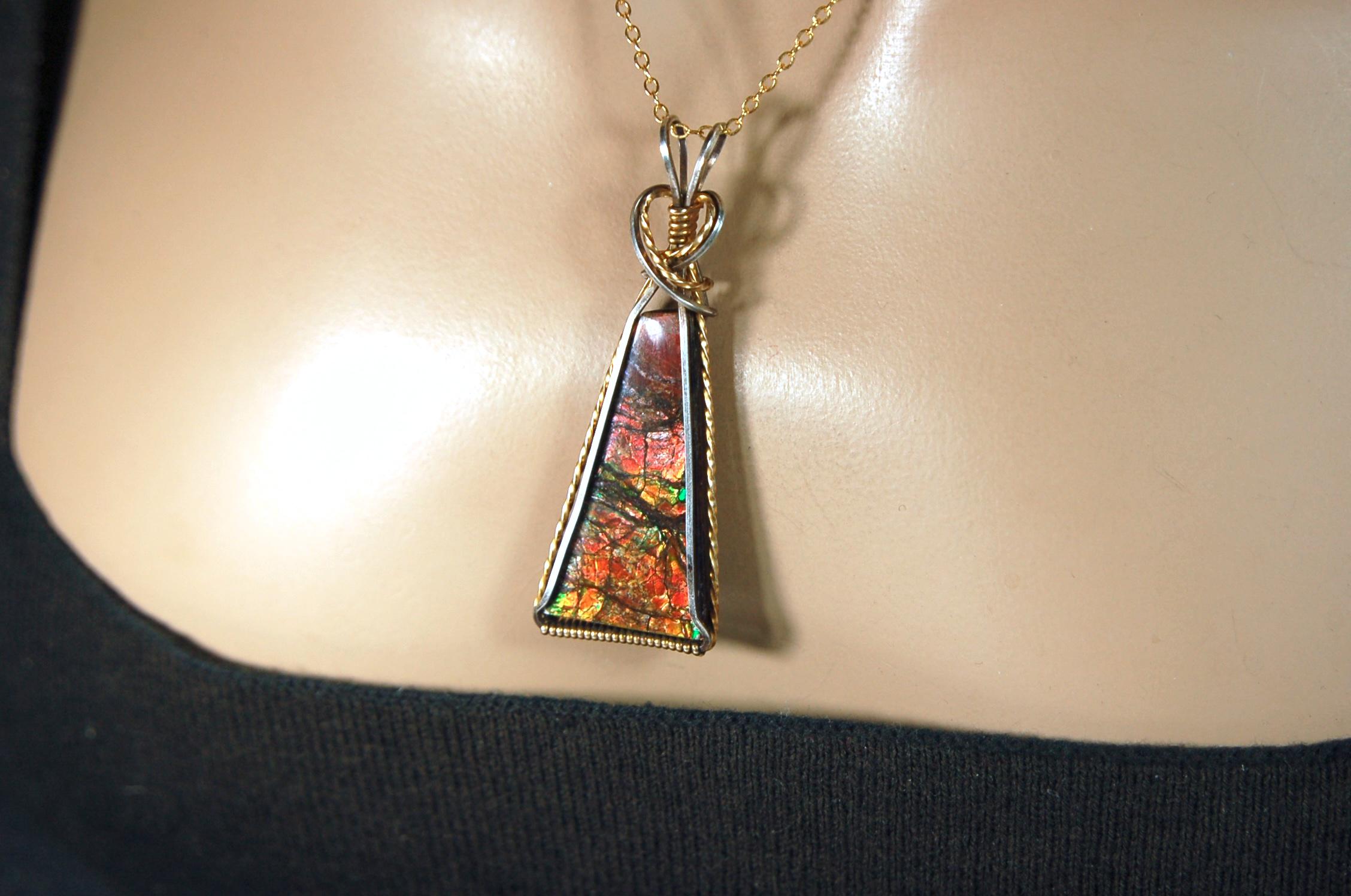 Unique Ammolite pendant set in Gold and sterling silver wire wrap.Natural cabochon in Canadian Maple fall colors.Must see video.082814