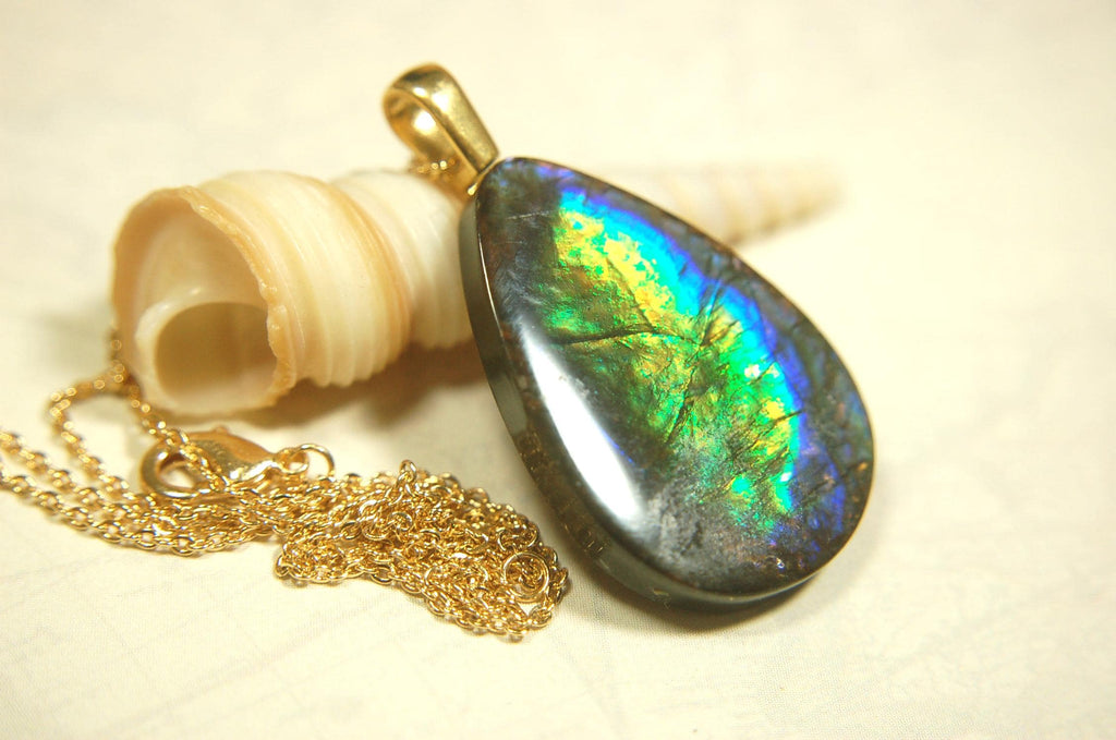 Ammolite Pendant with peacock colors.Natural cabochon gemstone mined and shipped from Canada.Gift of unique jewelry..020926