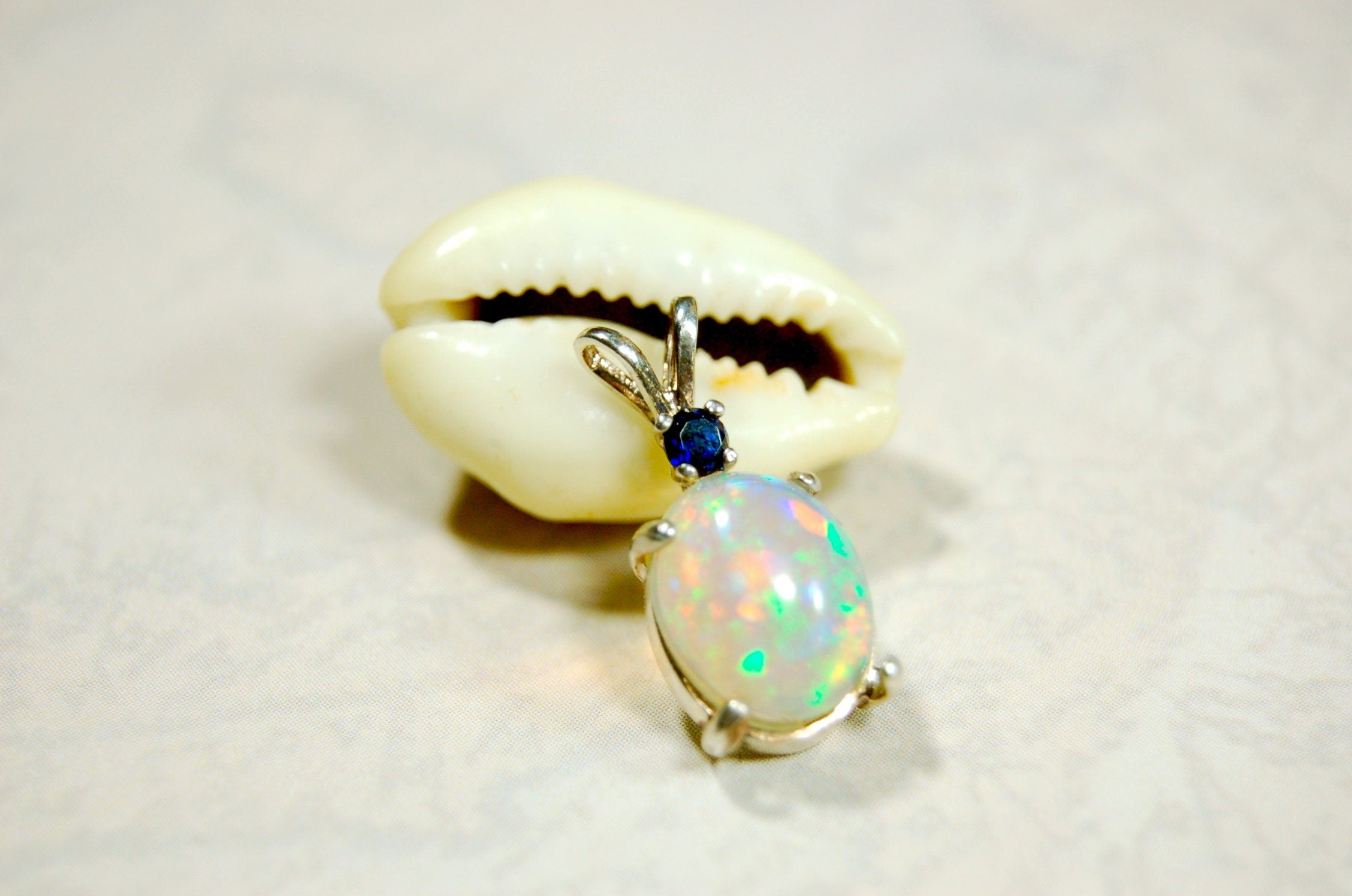 Natural opal pendant with blue sapphire.Good quality with many colors.The perfect gift.Must see video for true colors.042114