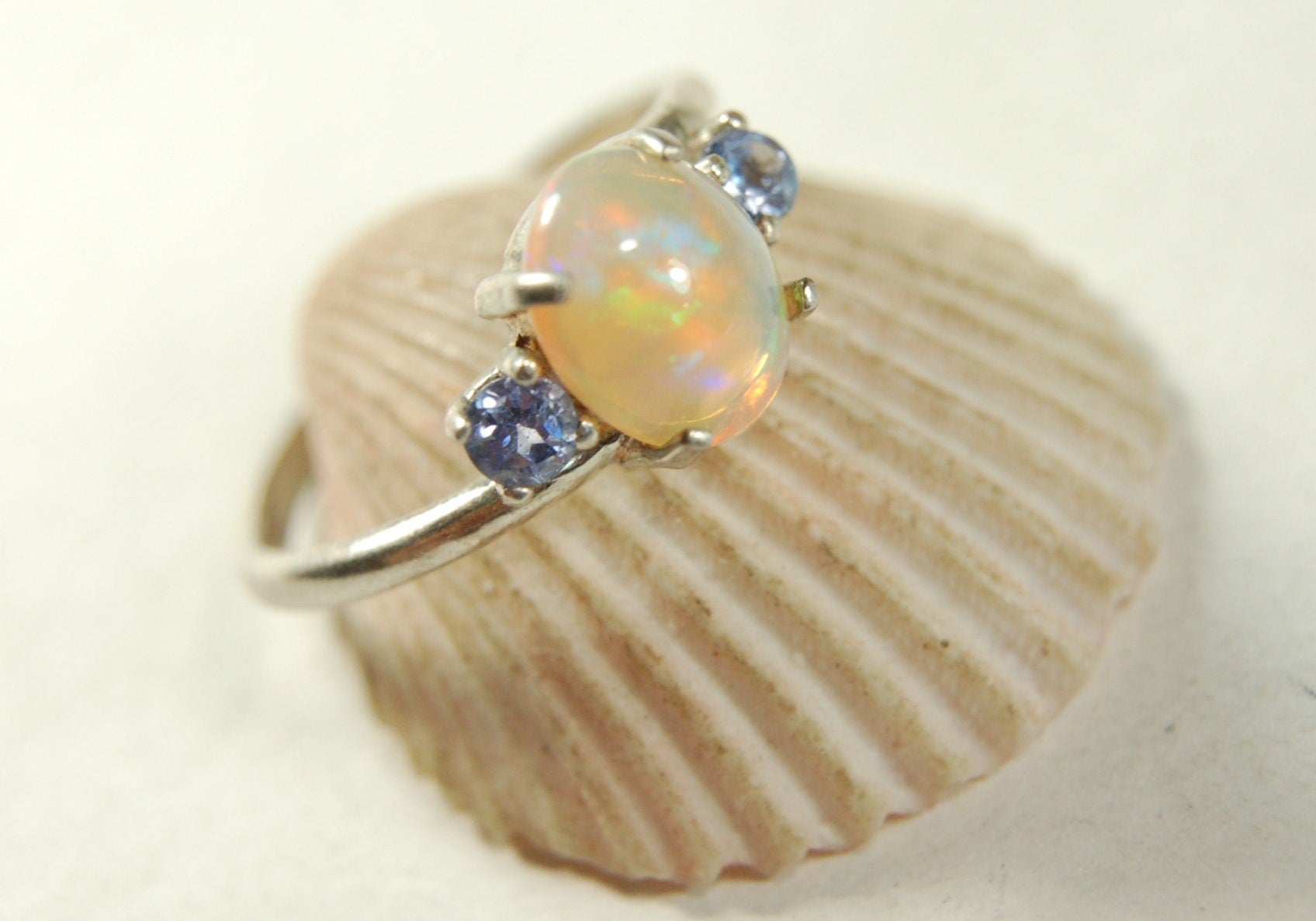 Opal ring.Solid African opal set in sterling silver with London Blue Topaz accent stones.Very feminine in size 6.