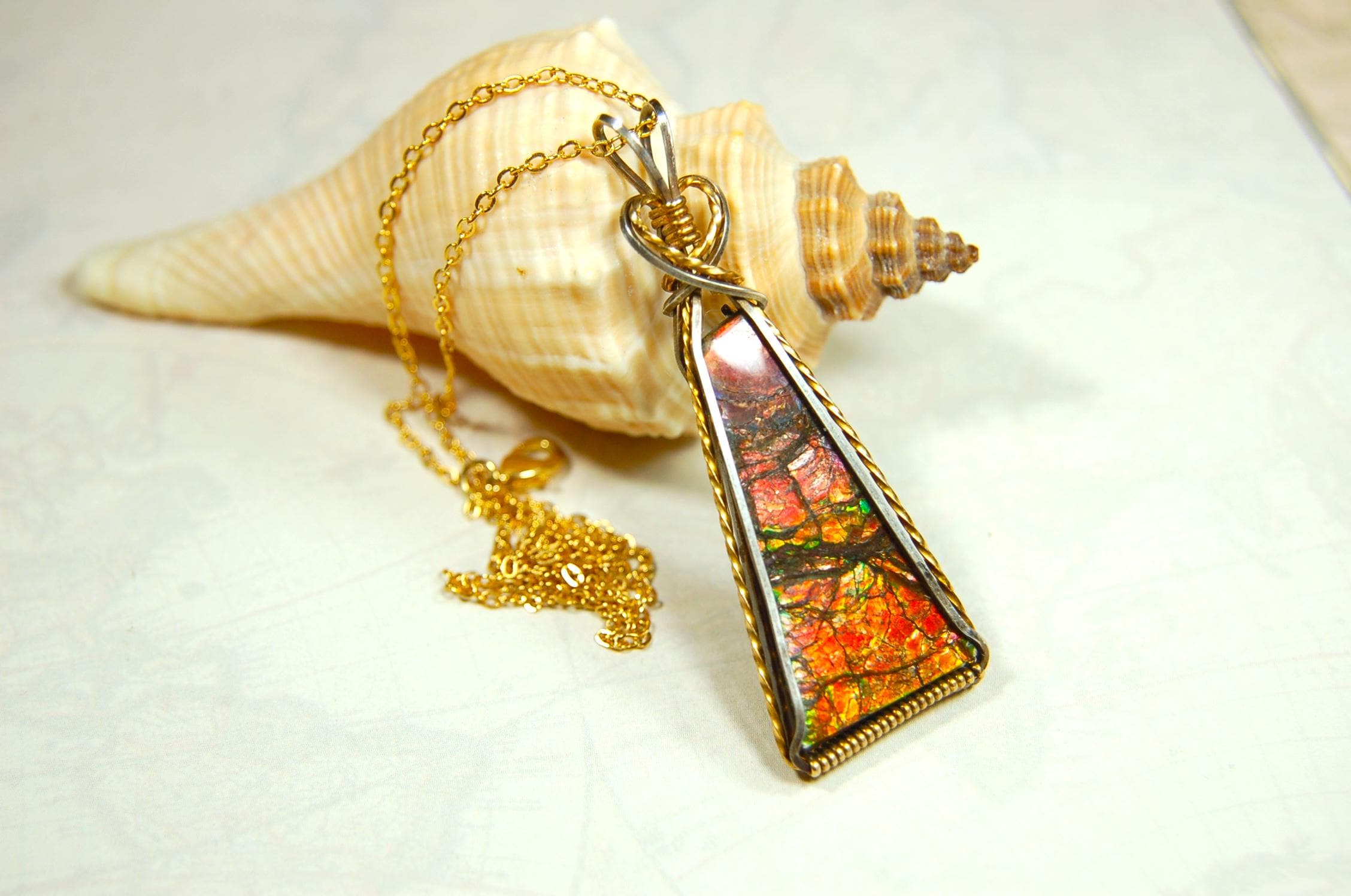 Unique Ammolite pendant set in Gold and sterling silver wire wrap.Natural cabochon in Canadian Maple fall colors.Must see video.082814