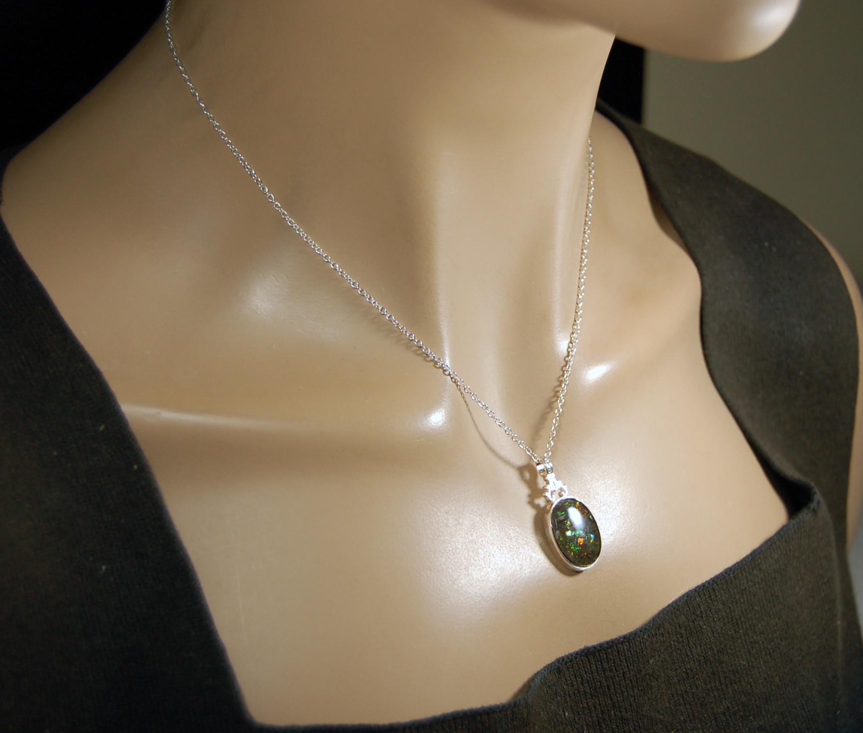 Ammolite Pendant.Rare sparks of color.Looks like a black Opal.One of a kind gem.Rare gift for her.Sterling Silver setting.022316