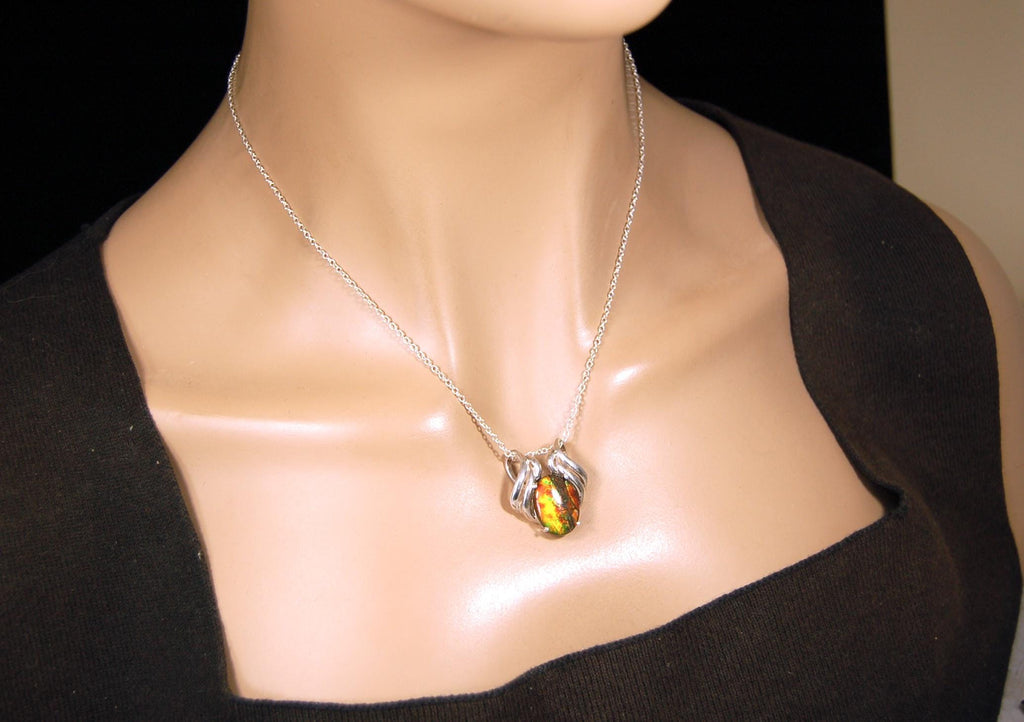 Ammolite pendant of unusual color pattern in a rare sterling silver setting.The green/copper colors are striking.022116