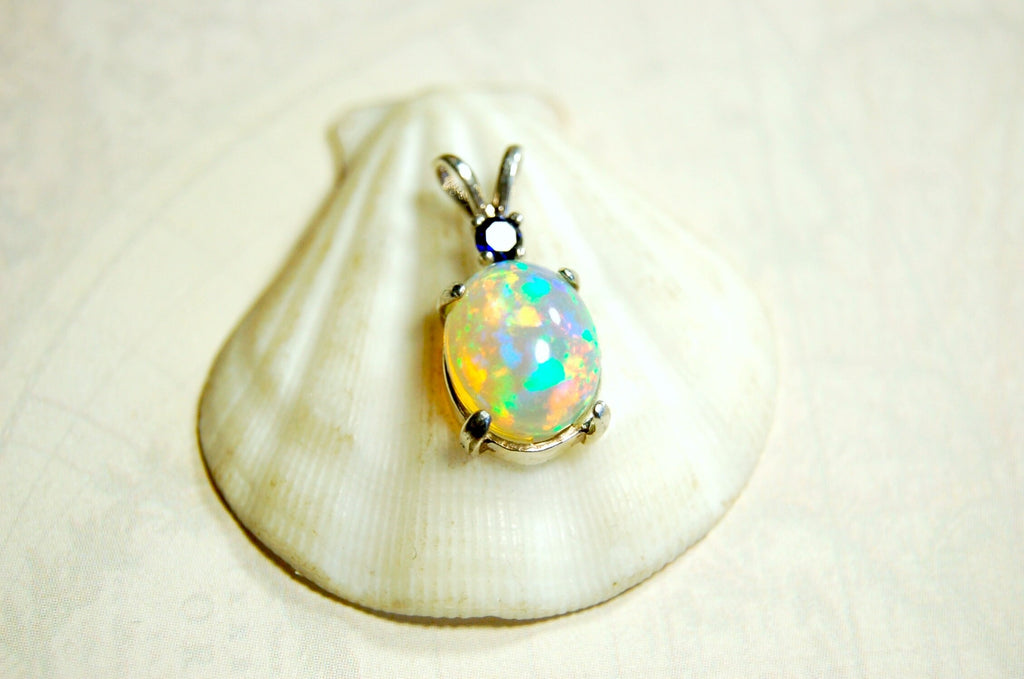 Natural opal pendant with blue sapphire.Good quality with many colors.The perfect gift.Must see video for true colors.042114