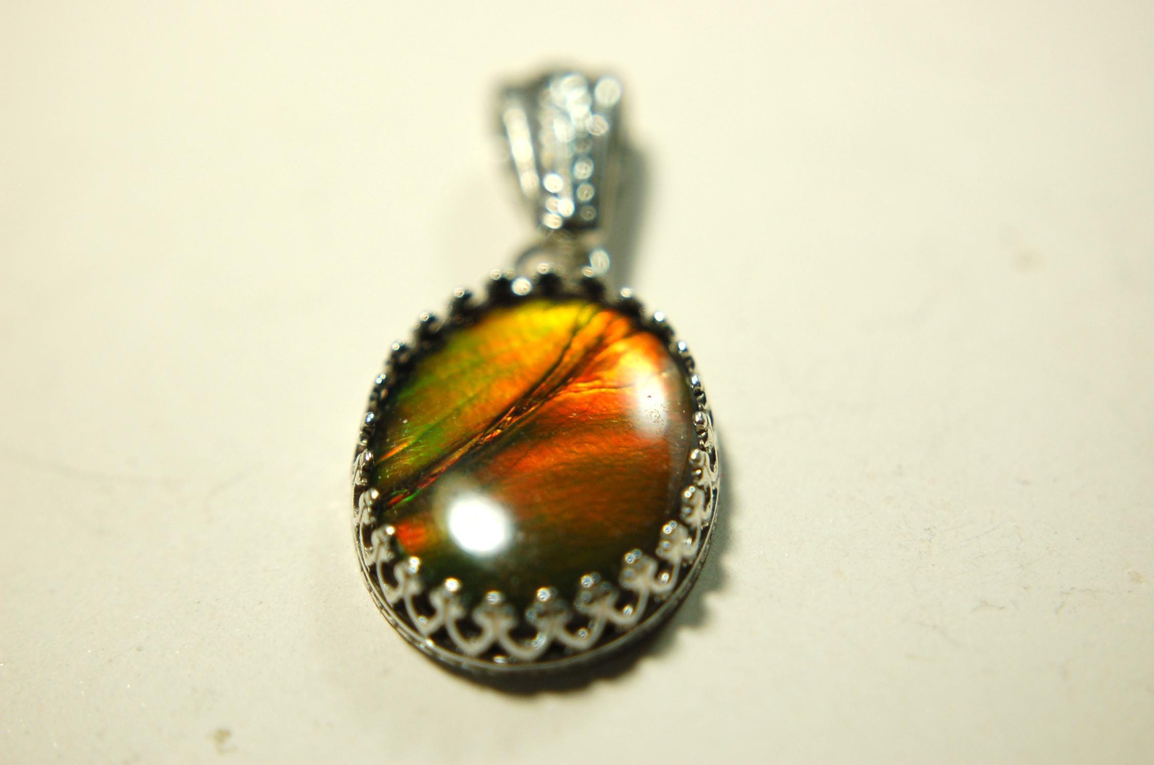 Ammolite Pendant Necklace.Resembles a fiery coal.Strong color shifter.Duty free under CUSMA rules.022115