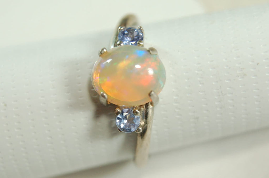 Opal ring.Solid African opal set in sterling silver with London Blue Topaz accent stones.Very feminine in size 6.