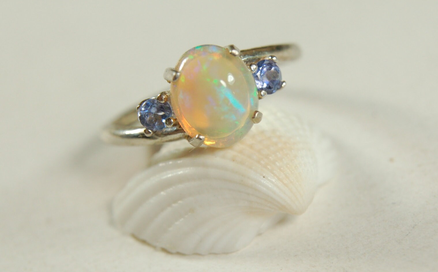 Opal ring.Solid African opal set in sterling silver with London Blue Topaz accent stones.Very feminine in size 6.