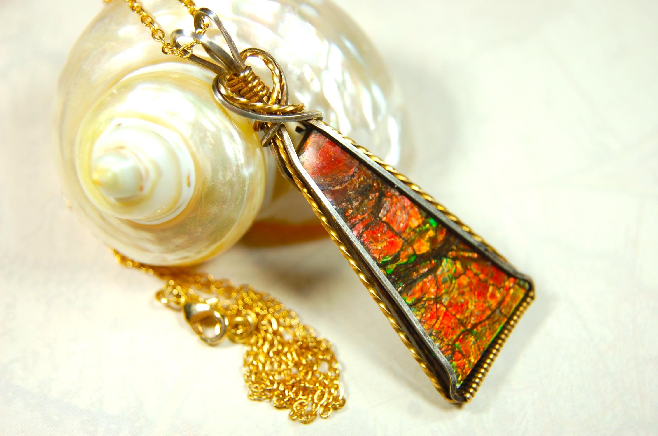 Unique Ammolite pendant set in Gold and sterling silver wire wrap.Natural cabochon in Canadian Maple fall colors.Must see video.082814