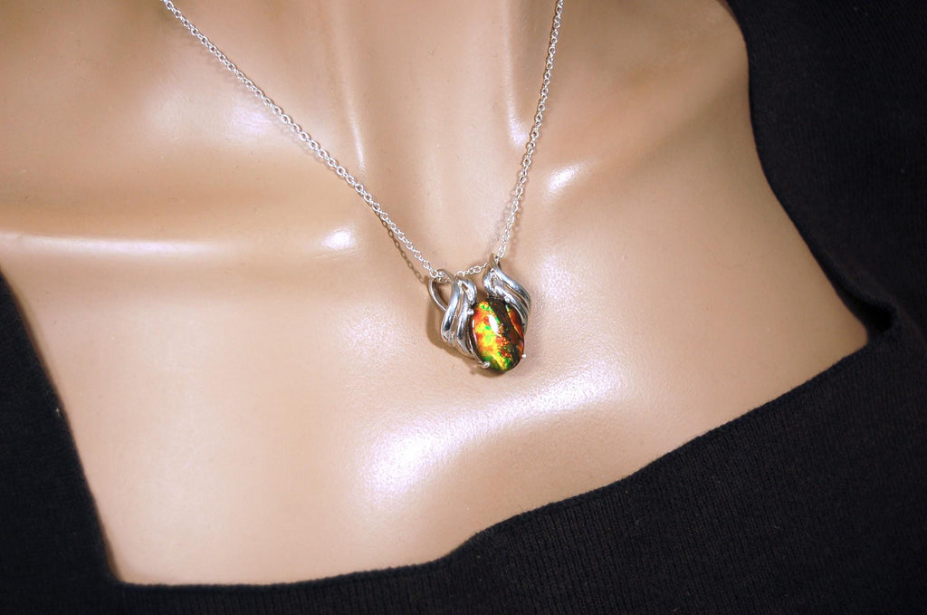 Ammolite pendant of unusual color pattern in a rare sterling silver setting.The green/copper colors are striking.022116