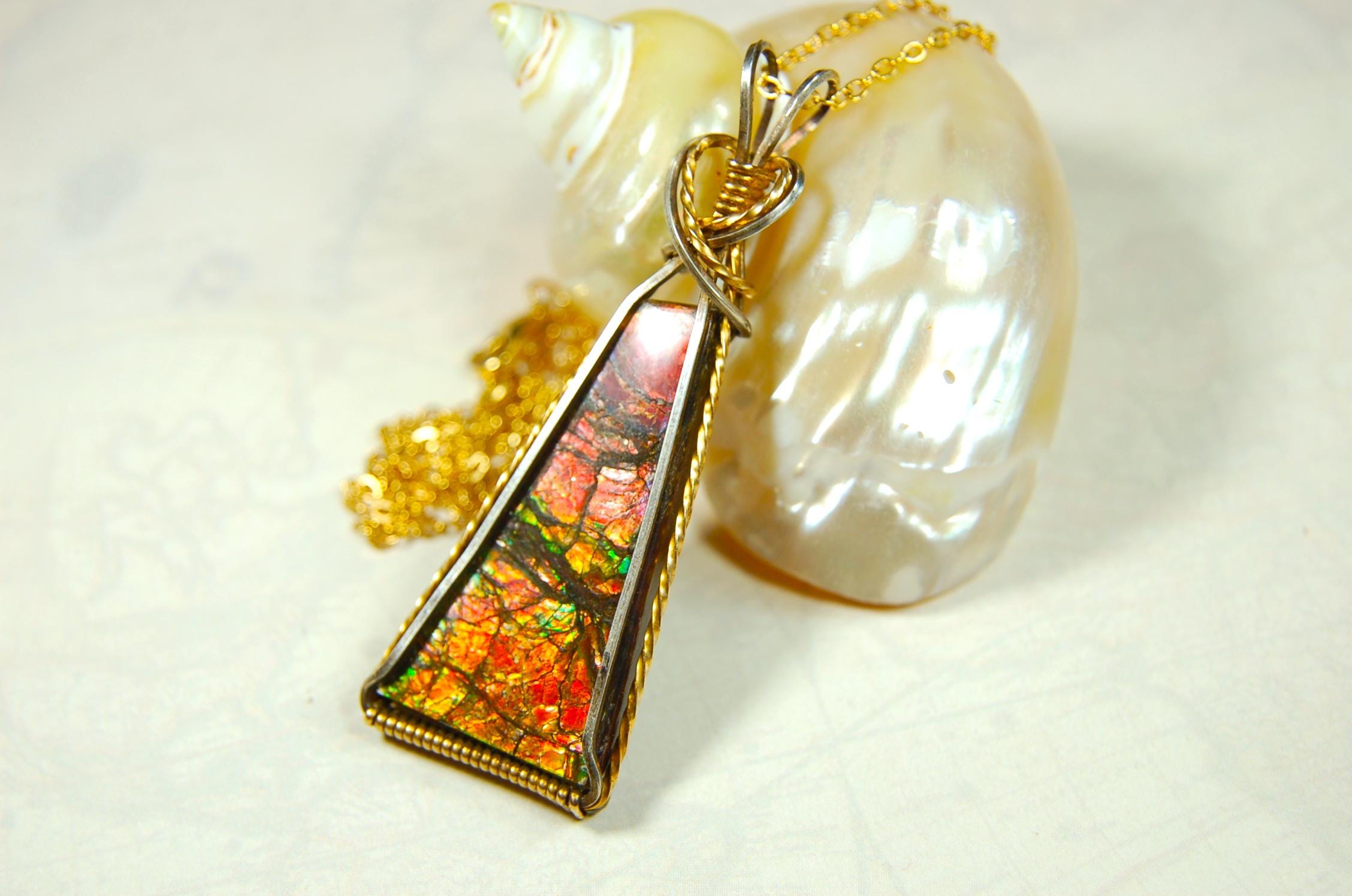 Unique Ammolite pendant set in Gold and sterling silver wire wrap.Natural cabochon in Canadian Maple fall colors.Must see video.082814