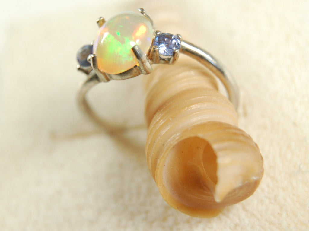 Opal ring.Solid African opal set in sterling silver with London Blue Topaz accent stones.Very feminine in size 6.