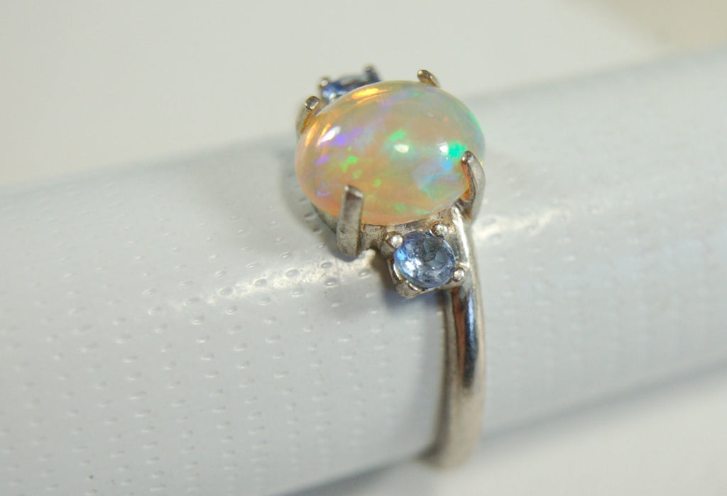 Opal ring.Solid African opal set in sterling silver with London Blue Topaz accent stones.Very feminine in size 6.